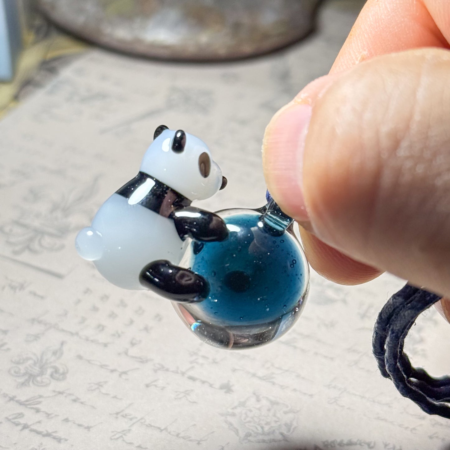 宇宙を抱っこするパンダペンダント